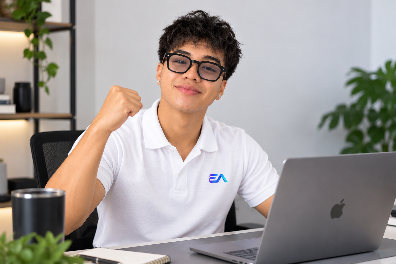 A smiling EA Co. learner working at his laptop